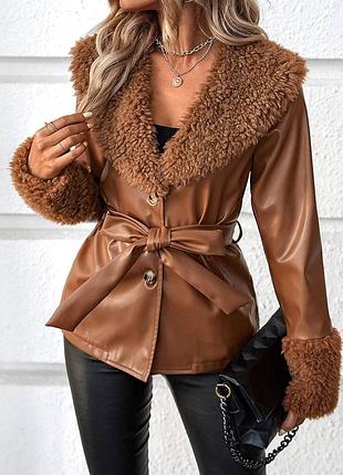Жіноча куртка-піджак зі штучної шкіри з поясом та коміром і манжетами зі штучного хутра.