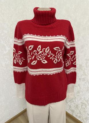 Червоний светр із високим коміром та вишивкою.