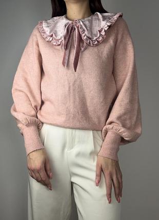 В’язаний светр ніжно-рожевого кольору має об’ємні рукави-ліхтарики з манжетами в рубчик. акцентною деталлю є великий знімний оксамитовий комір-рюш
