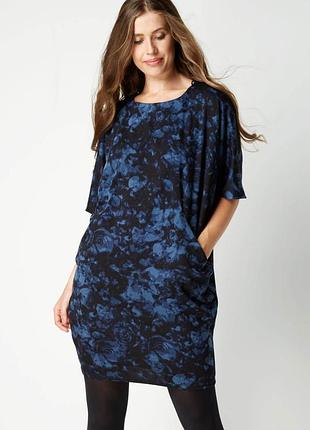 Сукня являє собою модель «кокон» або oversize у синьо-чорній кольоровій гамі з квітковим принтом, що нагадує троянди.