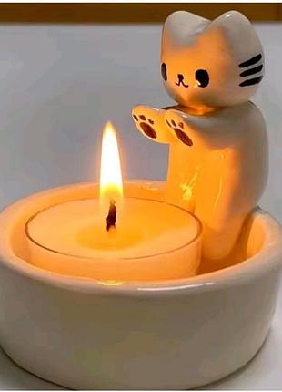 Подсвечник котик греет лапки.