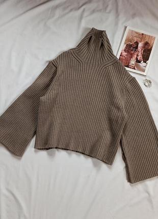 Щільний коричневий светр з високою горловиною та широкими рукавами