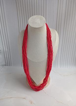 Длинное красное ожерелье.