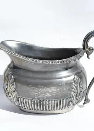 Антикварный молочник изысканной формы с рельефным орнаментом.