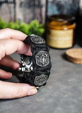 Браслет с бусинами со скандинавскими символами и застежкой рысь из белой бронзы в плетении из паракорда