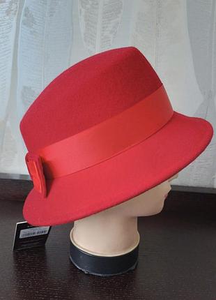 Фетровая шляпа с полями украшенная лентой и бантиком красная