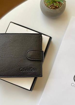 Чоловічий гаманець шкіряний на кнопці саlvіn klеіn модний чорний із відділенням для документів і монет портмоне з тисненням клянь кляйн