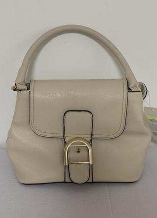 Маленькая бежевая сумка.