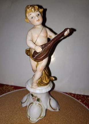 Старенька статуетка путті, ангел музика