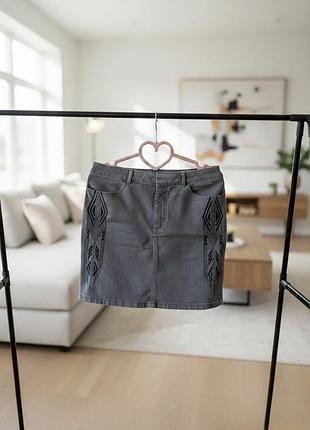 Джинсова спідниця від бренду h&m, в універсальному темно-сірому кольорі з виразною чорною вишивкою з обох боків, що має етнічні та геометричні мотиви.