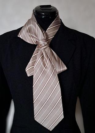 Вишукана жіноча краватка нейтральних кольорів з прикрасою.