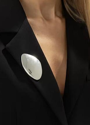 Абстрактная металлическая брошь в серебристом цвете в виде гладкого овального камня