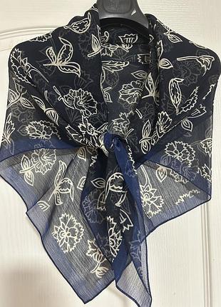 Женский платок от бренда next ladieswear. он изготовлен в италии и имеет темно-синий цвет с белым цветочным принтом.