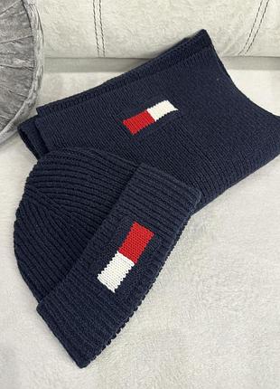 Это комплект из шапки и шарфа tommy hilfiger темно-синего цвета с логотипом-флагом