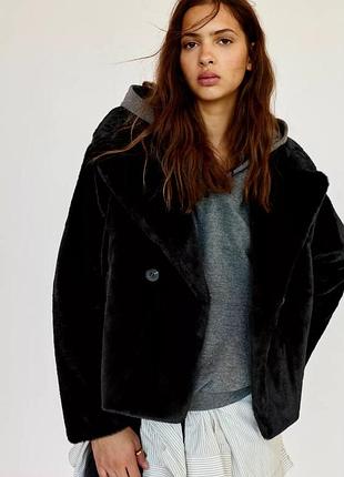 Коротке пальто зі штучного хутра з довгими рукавами, лацканами та кишенями. застібається на ґудзики.