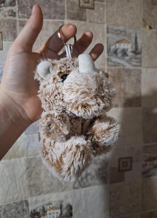 Плюшевый брелок в форме динозавра или носорога.