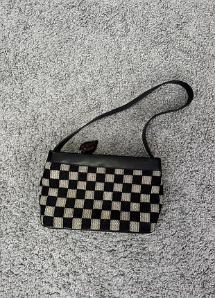 Стильна сумка з геометричним шаховим візерунком у чорно-бежевих тонах.