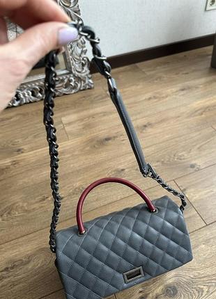 Сумка із еко шкіри сірого кольору під chanel.ручка маленька та великий ремінець на плече.фурнітура не ушкоджена.