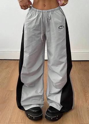 Незвичайні жіночі спортивні штани з плащівки оверсайз крою з лампасами середньої посадки зі шнурком