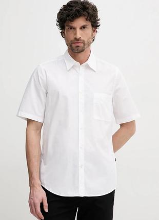 Біла чоловіча сорочка з коротким рукавом виконана у класичному стилі та має нагрудну кишеню.