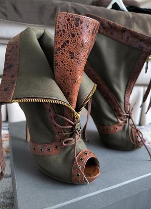 Ботильоны alexander mcqueen, отличающиеся характерным дизайном с открытым носком и деталями в виде черепа на молнии.