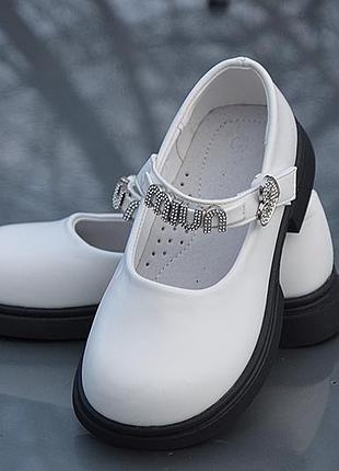 Стильні білі туфлі на дівчинку на чорній підошві