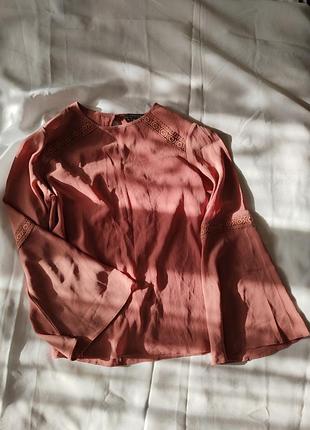 Жіноча блуза з мереживною обробкою та розкльошеними рукавами.