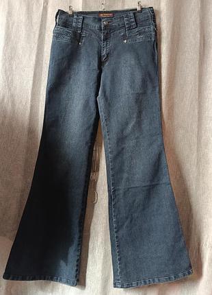 Джинсы женские темно синего цвета расклешенные.