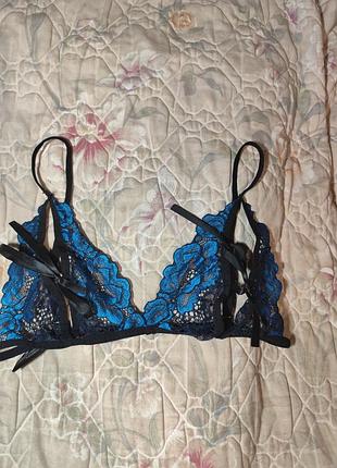 Женский открытый бюстгальтер с ярким синим кружевом на черной основе.