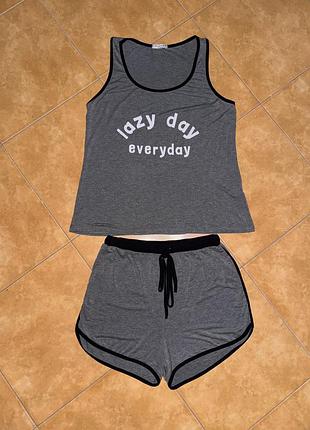 Комплект домашнього одягу складається з майки з написом «lazy day everyday» і шортів із зав'язками.