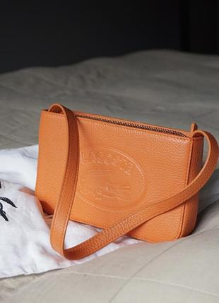 Яскрава оранжева сумочка lacoste