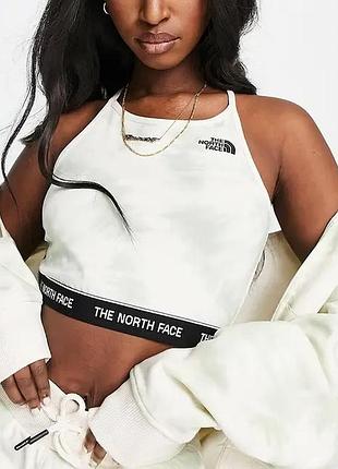 Білий жіночий кроп-топ від бренду the north face.