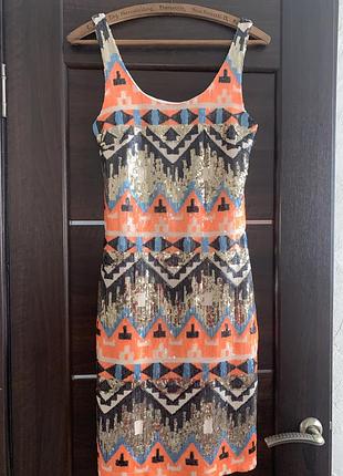 Яскрава коктейльна сукня з геометричним візерунком та пастками.