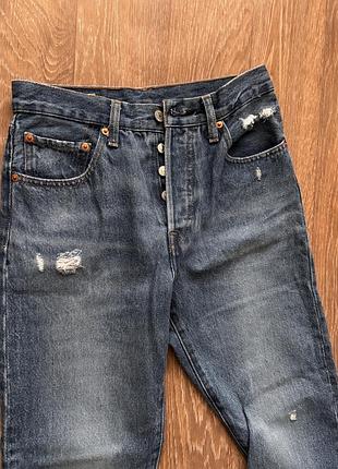 Це джинси levi's моделі 501, що вирізняються класичним прямим кроєм та фірмовою застібкою на ґудзиках.