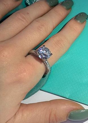 Кольцо tiffany, серебро 925 пробы. крупный циркон и мелкие цирконы по ребру кольца / упаковано в мешочек