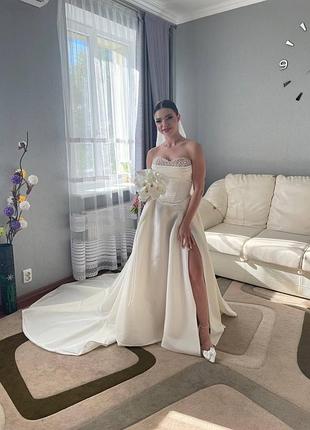 Весільна сукня з шлейфом в кольорі айворі з відкритими плечима