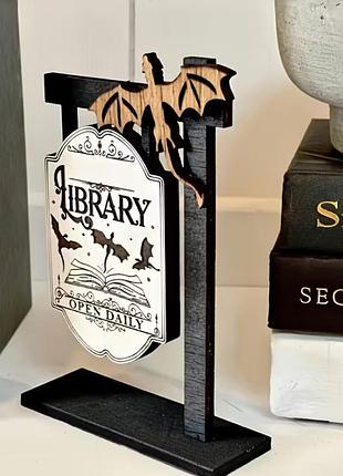 Декоративная фигурка с драконами и вывеской «library — open daily»