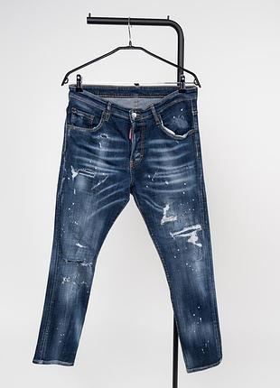 Чоловічі джинси dsquared2 tidy biker у синьому денімі з ефектом зношення та фарбовими бризками. модель має фірмовий байкерський