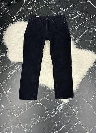 Чорні джинси — це модель levi's 505 regular fit, відома своїм класичним прямим кроєм, застібкою-блискавкою та посадкою на талії.