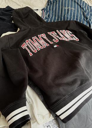 Tommy jeans худі, чорне. великий арочний принт “tommy jeans” на спині, маленький прапорець-лого на грудях, білі смуги на манжетах та низу.