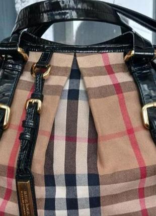 Жіноча сумка від бренду burberry в класичну клітинку з обробкою з чорної лакованої шкіри
в ідеальному стані
