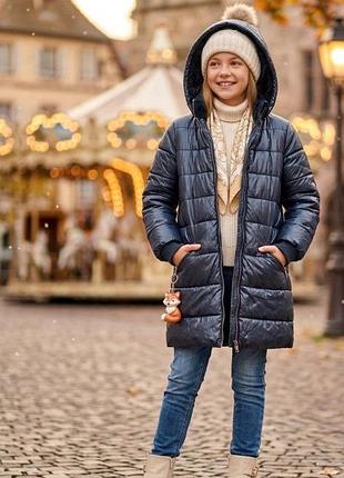 Селиконовое пальто удлиненное бренда м&amp;s на девочку 11-12 лет с капюшоном и карманами на молнии.с мягким искусственным мехом в капюшоне и чуть ниже