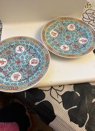 Китайські порцелянові тарілки з візерунком "wan shou wu jiang" (або "mun shou") на бірюзовому тлі.