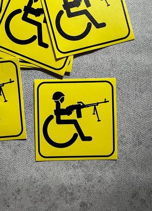 Вінілова наліпка на авто людина з інвалідністю з кулеметом 10х10 см жовтий