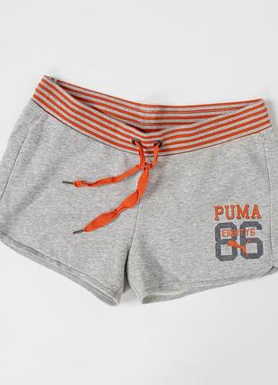 Жіночі шорти puma світло-сірого кольору з яскравими, помаранчевими акцентами та брендованим принтом спереду. модель має м’який, трикотажний матеріал,