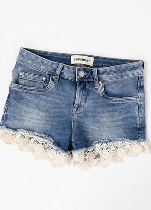 Жіночі, джинсові шорти superdry світло-синього кольору з мереживним оздобленням по низу. модель має стильний distressed denim look із