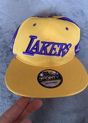 Кепка los angeles lakers від бренду new era. це модель 9forty adjustable, що підтверджується оригінальною наклейкою на козирку.