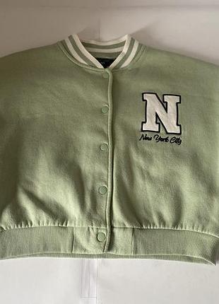 Підліткова куртка-бомбер у стилі «varsity» від бренду new look. 12-13 р., куртка-бомбер new look цвета шалфея с белыми рукавами и логотипом «new york»