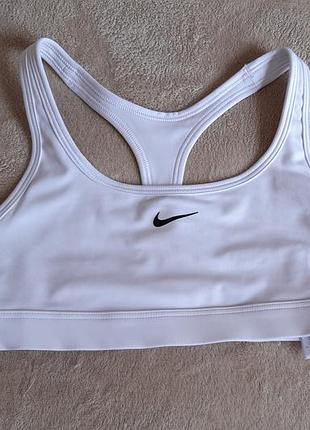 Білий спортивний топ nike dri-fit із чорним логотипом swoosh.