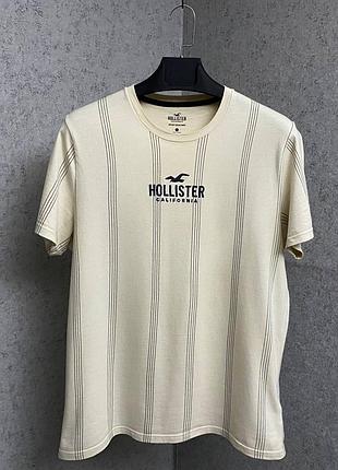 Бежева смугаста футболка від бренду hollister